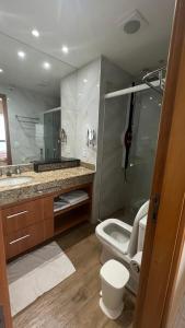 a bathroom with a toilet and a sink and a mirror at Flat no Condomínio do Edifício Tropical Executive e residence com Vista para o Rio in Manaus