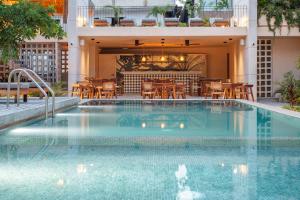 a swimming pool with tables and chairs in a building at Faisano Nomadas in Tulum