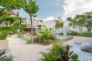 an external view of a house with a swimming pool and plants at Faisano Nomadas in Tulum