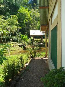 a building with a green door next to a garden at Cabinas jugle jause in Drake