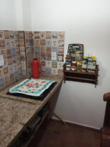 a kitchen counter with a cake on a table at Mini Casa Furnas - Capitólio MG in São José da Barra