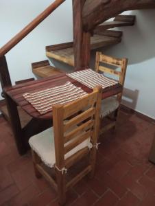 una mesa de madera y 2 sillas junto a una escalera en Mini Casa Furnas - Capitólio MG en São José da Barra