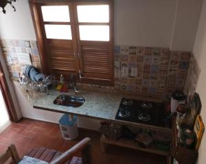 a kitchen with a counter and a sink and a window at Mini Casa Furnas - Capitólio MG in São José da Barra