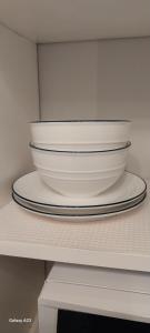 two bowls on a shelf in a white cabinet at 66 Chaucer B&B with Complimentary Breakfast in Cambridge