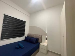 - une chambre avec un lit doté d'oreillers bleus et d'une fenêtre dans l'établissement Amber Cove - Impression City Melaka l 2BR2R l WiFi l 6-10Pax, à Malacca