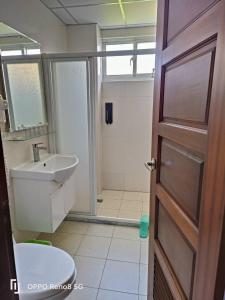 a bathroom with a toilet and a sink and a door at 茶樂二重奏 in Taitung City