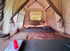 ein offenes Zelt mit einem Bett in der Mitte in der Unterkunft Nậm Lỳ Retreat- Breakfast included in Ha Giang