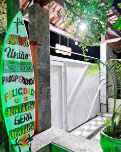 a surfboard sign in front of a garage at Recanto dos Loureiros in Saquarema