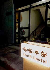 PingtanにあるMeow! Marcia Youth Hostelの建物内のユースホステルを読む看板