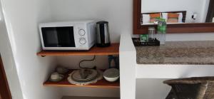 un four micro-ondes installé sur une étagère dans une cuisine dans l'établissement DB Studios Samui, à Lamai