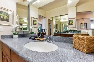 a bathroom with a sink and a mirror at Hololani A404- Ocean views from every room, 2 bedroom condo in Kahana +40 photos