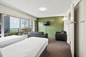 a hotel room with two beds and a balcony at Heartland Ambassador Hotel Hamilton in Hamilton