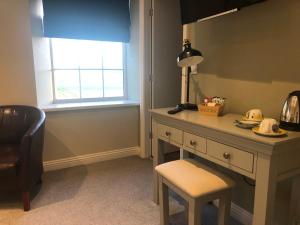 a room with a desk with a chair and a window at The Fox Hall Inn in Richmond