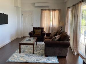 a living room with two chairs and a coffee table at Catappa Condos in Morne Rouge