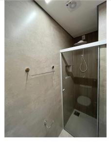 a bathroom with a shower with a glass door at Flats Uberlândia in Uberlândia