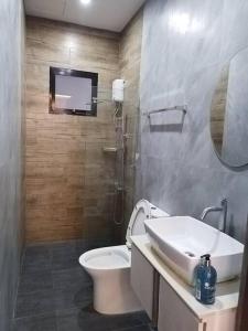a bathroom with a toilet and a sink and a mirror at Home in Bacolod in Bacolod