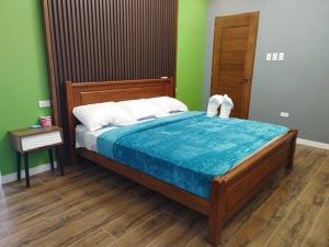 1 dormitorio con 1 cama con cabecero de madera en Home in Bacolod en Bacólod