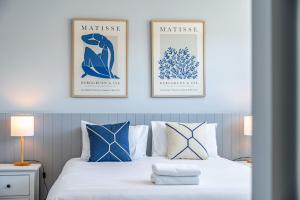 瓦納卡的住宿－Stylish Panoramic Mountain and Lake Views，卧室配有一张带两张挂在墙上的挂图的床