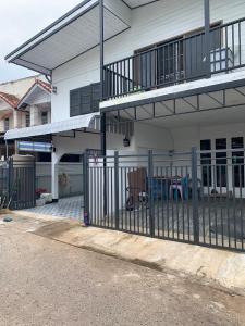 a fence in front of a house with a balcony at Udon House in Udon Thani