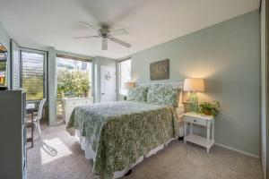 a bedroom with a bed and a table with a lamp at Hale Kamaole 7-169- Ground floor, ocean view, updated Kihei gem in Wailea