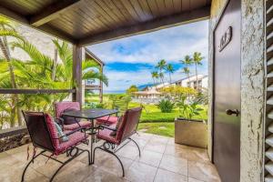 a patio with a table and chairs and a view of the ocean at Hale Kamaole 7-169- Ground floor, ocean view, updated Kihei gem in Wailea