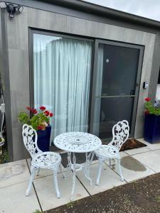 un tavolo bianco con due sedie e un tavolo con sedie di Great Ocean Road Wellness and Nature Stay a Apollo Bay