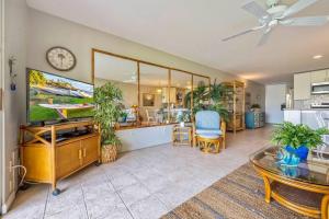 a living room with a table and a clock on the wall at Hale Kamaole 7-169- Ground floor, ocean view, updated Kihei gem in Wailea