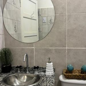a bathroom with a sink and a mirror at Los Geranios Apart in Villa Cubas