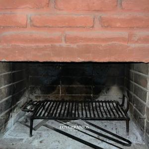 a black bench sitting in front of a brick wall at Los Geranios Apart in Villa Cubas