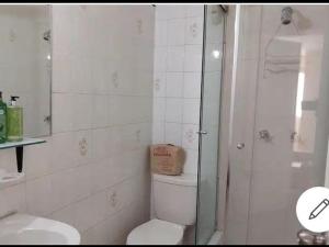 a white bathroom with a toilet and a shower at Espacioso departamento in Lima