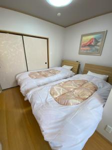 two beds in a room with white sheets at 君の家 東寺 in Kyoto