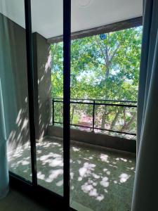 una puerta de cristal abierta con vistas a un balcón en Depto acogedor, moderno y espacioso en Rosario