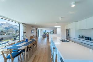 a kitchen with tables and chairs and a large window at Central Vista in Wanaka in Wanaka