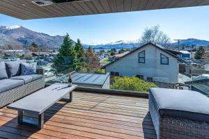 a patio with a couch and a table on a deck at Central Vista in Wanaka in Wanaka