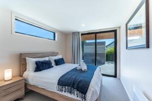 1 dormitorio con 1 cama con manta azul en Central Vista in Wanaka, en Wanaka