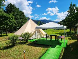 uma tenda com uma mesa e cadeiras num campo em Sora no Mori Hotel Hanagori em Muraoka