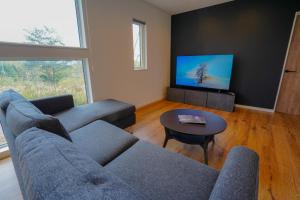 a living room with a couch and a tv at Soga House in Kabayama