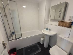 a white bathroom with a sink and a shower at Entire South London Apartment hosted by Pius in Croydon