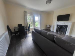 a living room with a couch and a fireplace at Entire South London Apartment hosted by Pius in Croydon