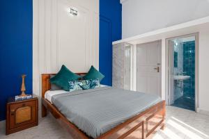 a bedroom with a bed with blue walls at Villa Calangute Phase 7 in Candolim +21 photos