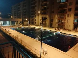 - une piscine sur le toit d'un bâtiment la nuit dans l'établissement Maravilloso Apartamento Girardot Ricaurte con vista Panorámica, à Ricaurte