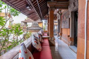 a porch of a building with pillows on it at Maharani Hostel in Ubud