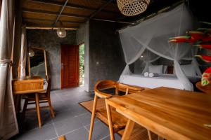um quarto com uma cama e uma mesa de madeira em Padangan Lodge By Bali Cabin em Padangan