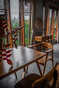 uma mesa de madeira e cadeiras num quarto com uma janela em Padangan Lodge By Bali Cabin em Padangan