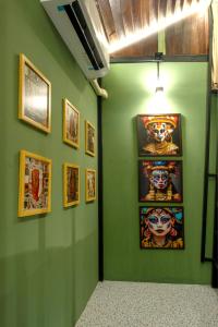 a green room with paintings on the wall at Rinvada House in Bangkok