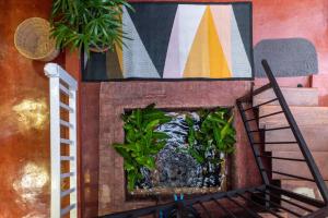 a fireplace with a plant in it next to a painting at Rinvada House in Bangkok +14 photos