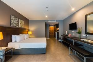 Habitación de hotel con cama y escritorio en Sea Me Spring Hotel, en Pattaya central
