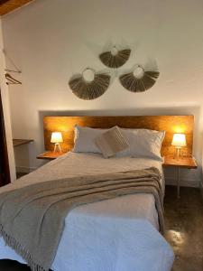 a bedroom with a large bed with two lights on it at Villas de Cieneguilla in Cieneguilla