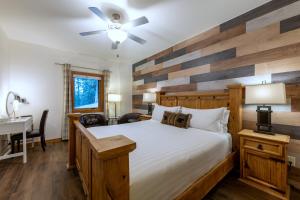 ein Schlafzimmer mit einem großen Bett mit einer Holzakzent-Wand in der Unterkunft Canyon Ridge Lodge in Golden