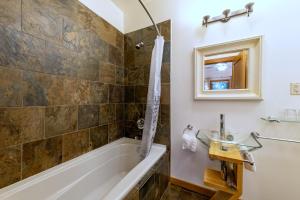 ein Badezimmer mit einer Badewanne und einem Waschbecken in der Unterkunft Canyon Ridge Lodge in Golden